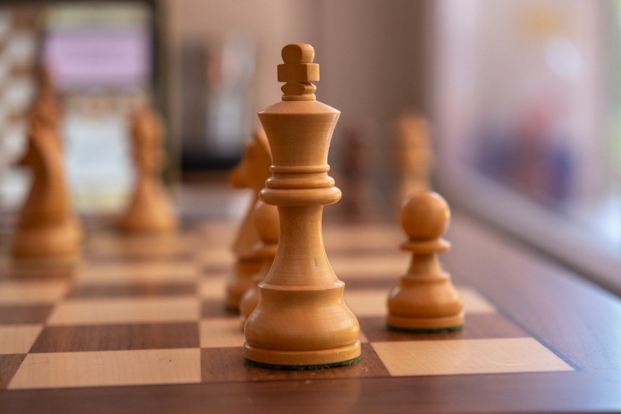 The Art of Drawing Readers In: Your attractive post title goes here Detailed shot of chess pieces with selective focus, featuring a queen and pawn on a wooden board.